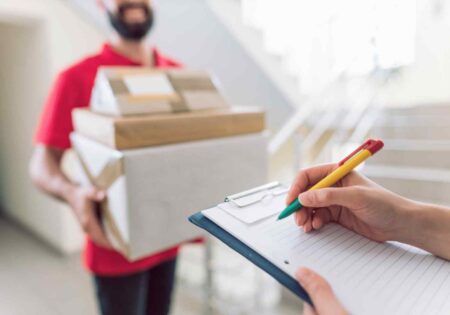 Holding parcel checking phone doorstep